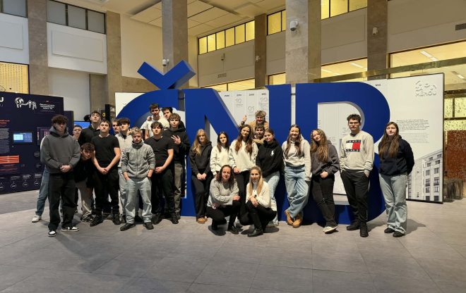 Skupina studentů stojící před velkou modrou instalací s písmeny ČNB uvnitř budovy banky.